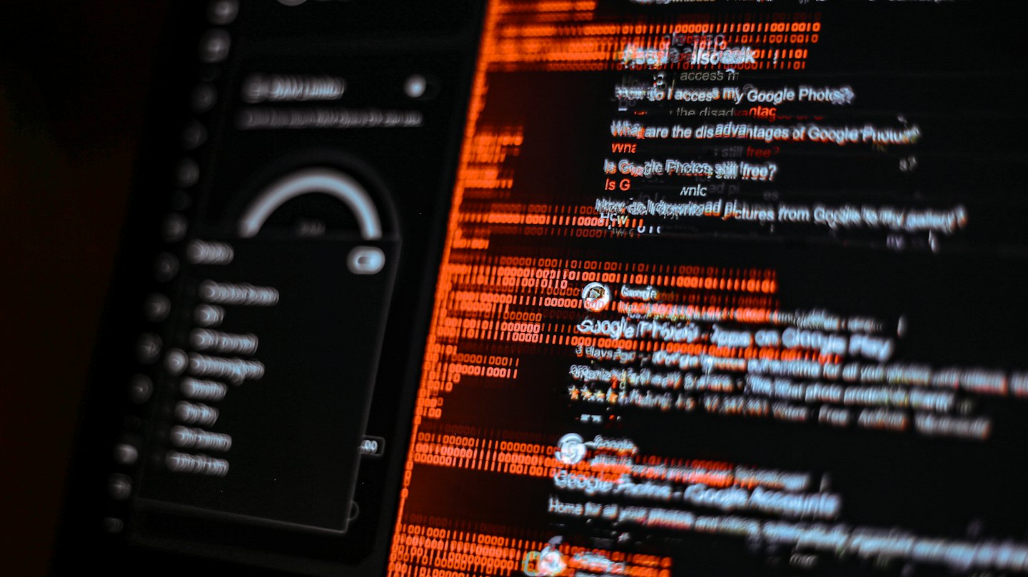 Digital screen displays fragmented data and orange binary code.